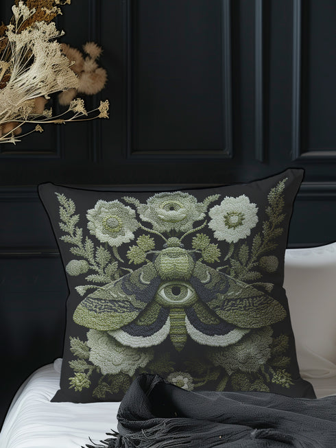 Luxury dark academia pillow cover in black featuring an embroidered-style veiled moth with an all-seeing eye, surrounded by intricate cream and sage florals and foliage, inspired by Victorian entomology and folklore. Square cushion, available in 18x18 or 22x22 inches, linen-feel premium polyester, double-sided print, hidden zipper.